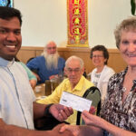 Le Club Français Treasurer Thérèse Dionne (right) presents Rev. Alex of the Christian Life Center with a check for $2,000 to support the center’s efforts to promote and preserve the French language. (Courtesy of Sharon Boucher)